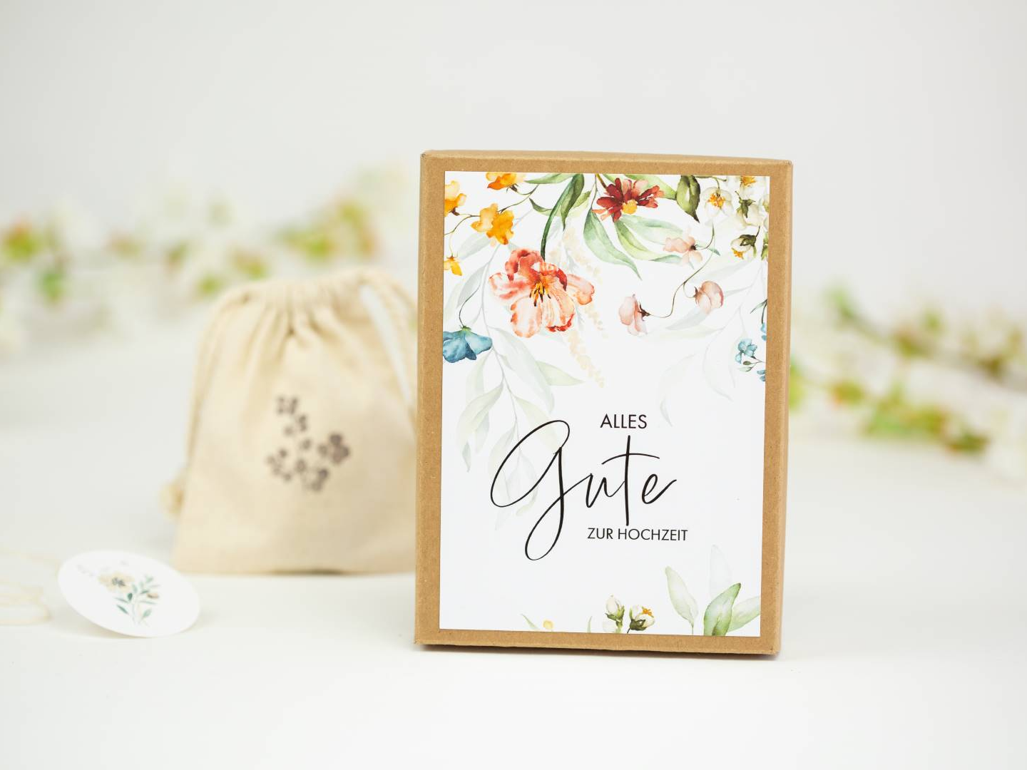 a card with a floral design on it next to a drawstring bag