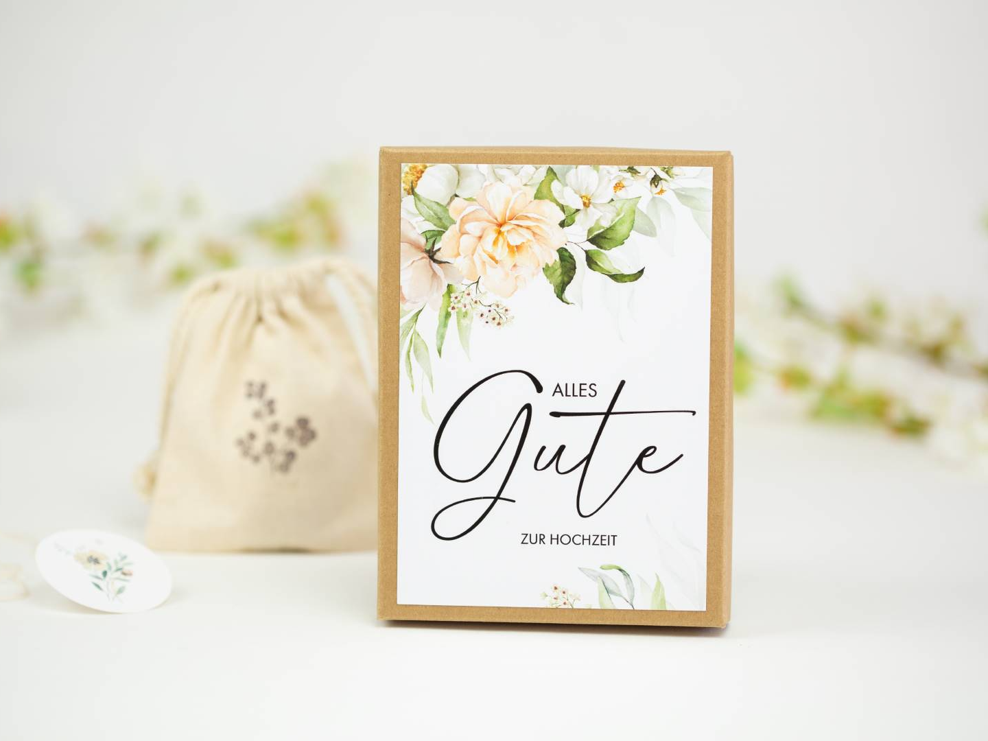 a card with a floral design on it next to a drawstring bag