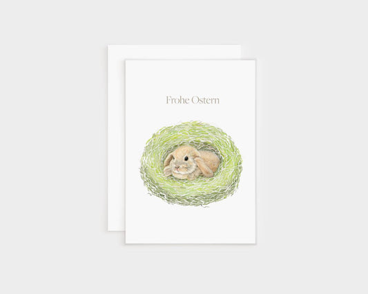 a greeting card with an illustration of a rabbit in a nest